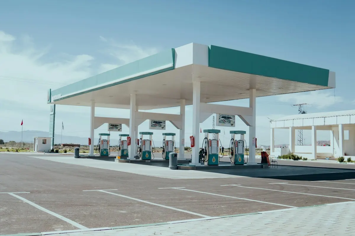 Estación de servicio con surtidores bajo un techo blanco