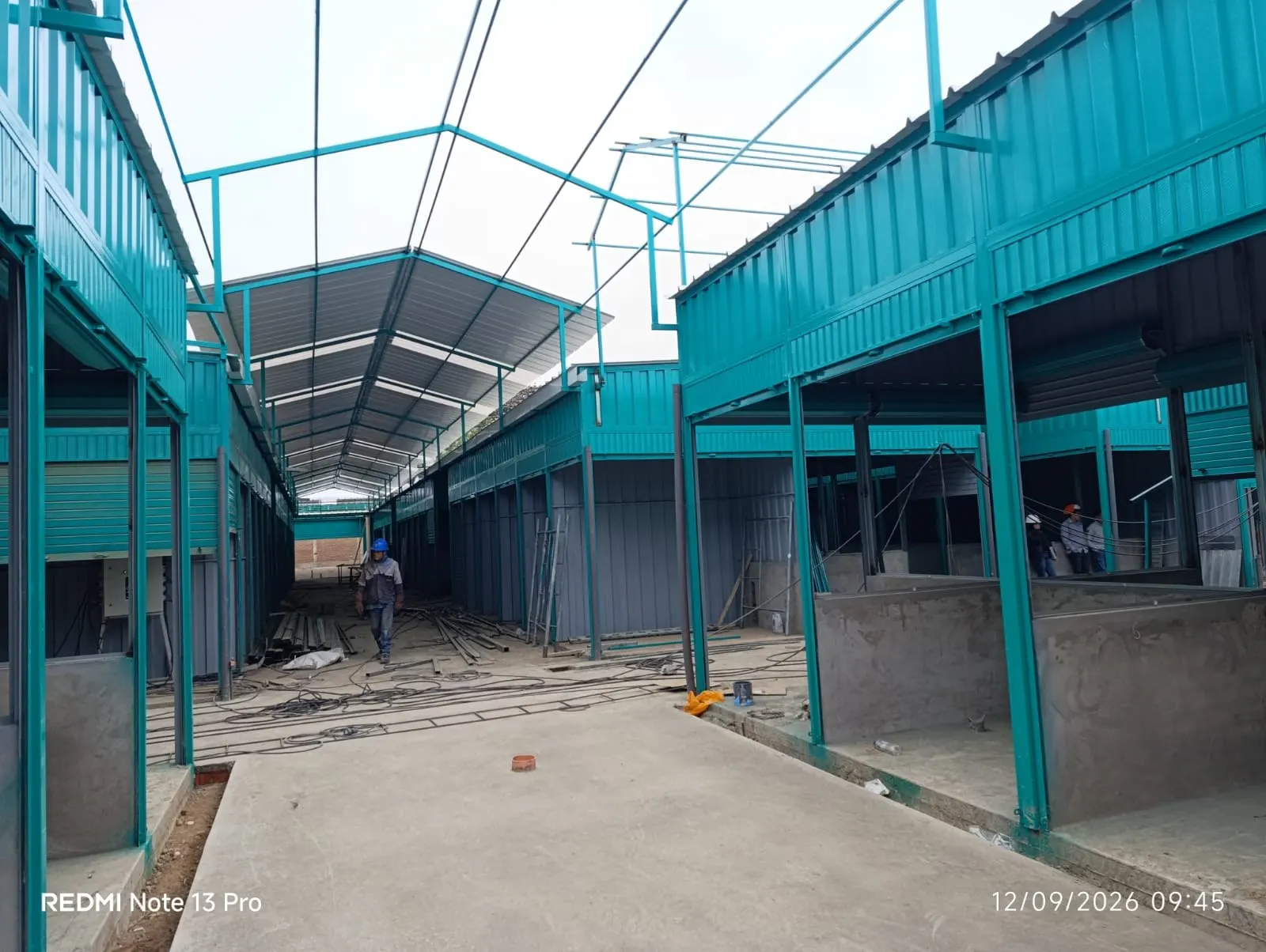 Pasillo entre módulos de locales comerciales con estructura metálica en construcción
